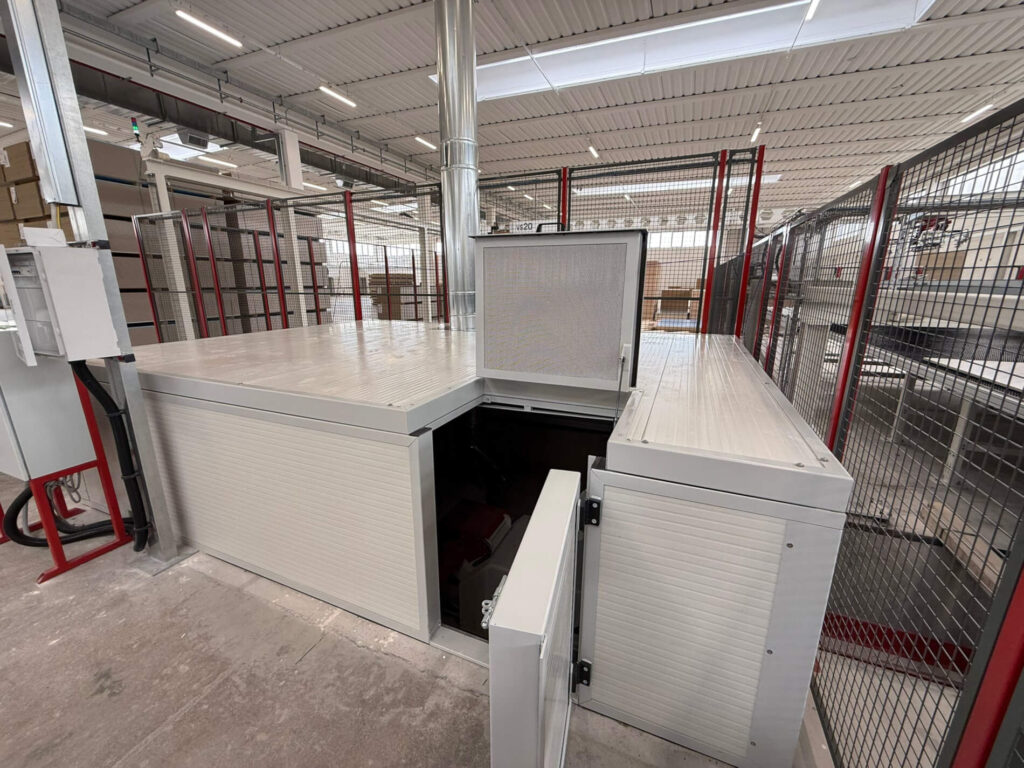 Cabina metallica di protezione per impianti industriali mostrata con gli sportelli di accesso e ispezione aperti. Progettazione, realizzazione e posa a cura di Carpenteria 2A, operativa in tutto il Veneto.