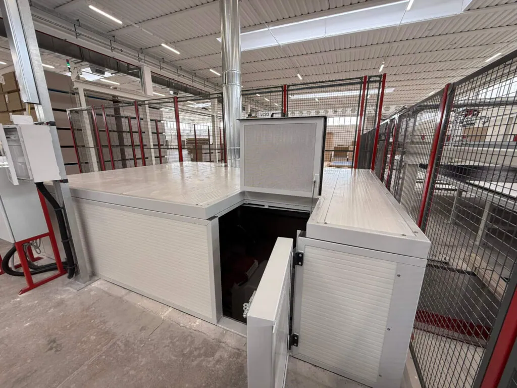 Cabina metallica di protezione per impianti industriali mostrata con gli sportelli di accesso e ispezione aperti. Progettazione, realizzazione e posa a cura di Carpenteria 2A, operativa in tutto il Veneto.