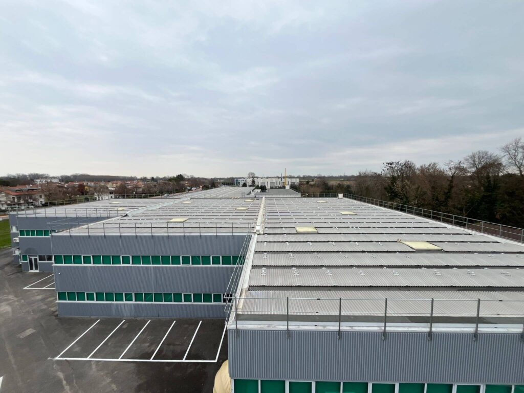 Vista aerea della copertura di un polo industriale messa in sicurezza tramite l'installazione di ringhiere perimetrali anticaduta in metallo zincato. Lavoro di carpenteria industriale in Veneto a cura di Carpenteria 2A.