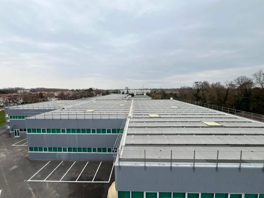 Vista aerea della copertura di un polo industriale messa in sicurezza tramite l'installazione di ringhiere perimetrali anticaduta in metallo zincato. Lavoro di carpenteria industriale in Veneto a cura di Carpenteria 2A.