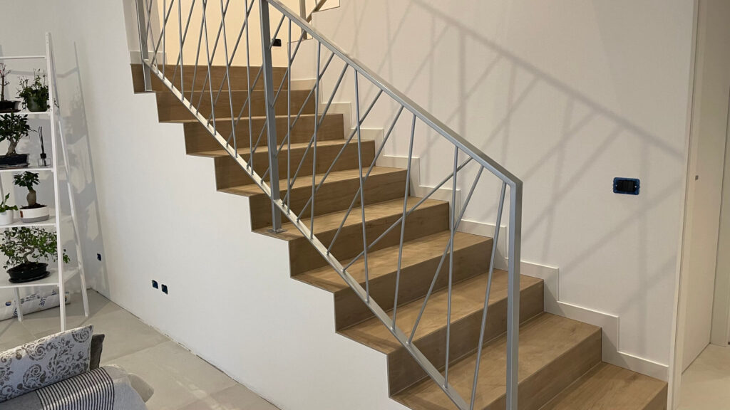 Parapetti per balconi e recinzione esterna coordinati per villa privata, realizzati in metallo scuro con design moderno a fasce orizzontali. Fornitura e posa di Carpenteria 2A, Treviso.