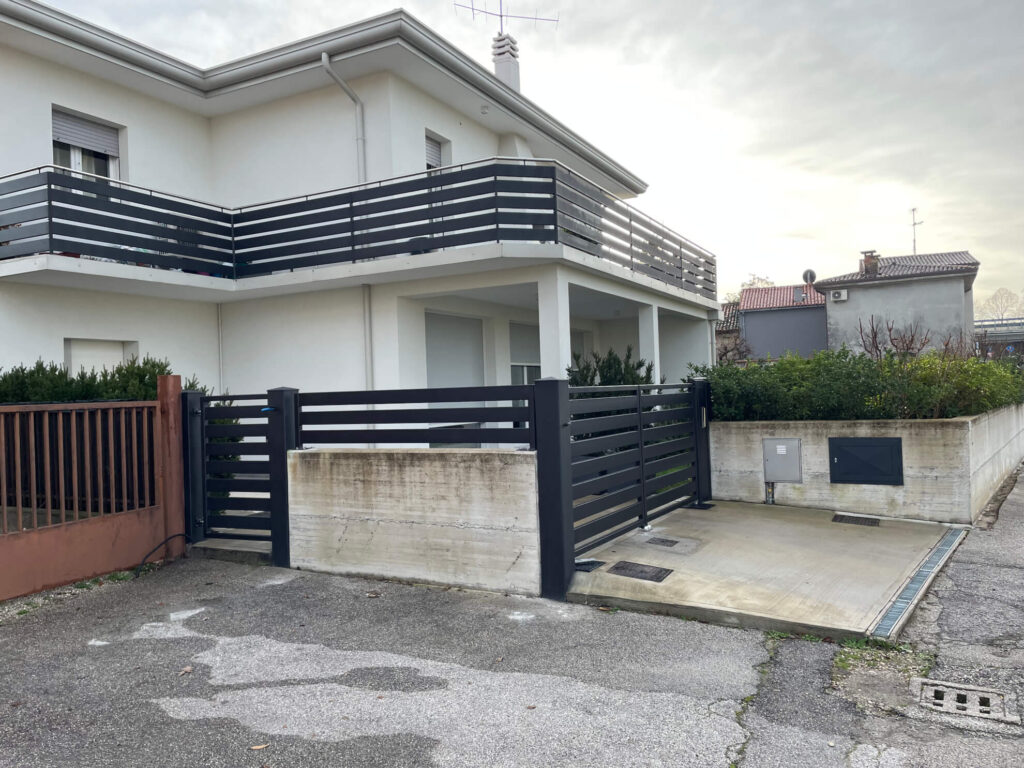 Parapetto per scala interna dal design moderno con motivo geometrico a incrocio, realizzato in metallo verniciato chiaro. Progetto di carpenteria d'interni a cura di Carpenteria 2A, Veneto.