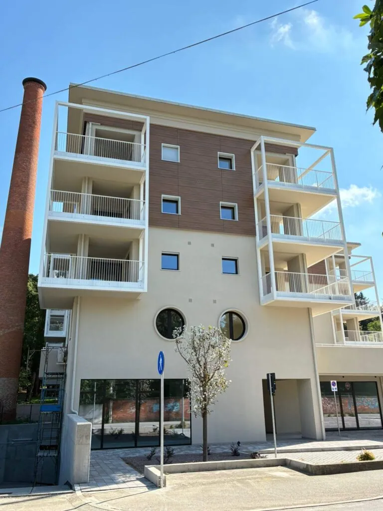 Strutture metalliche per ampi balconi e parapetti verniciati di bianco dal design lineare, installati sulla facciata di un moderno complesso residenziale. Opera di carpenteria per l'edilizia civile di Carpenteria 2A, operante in Veneto.